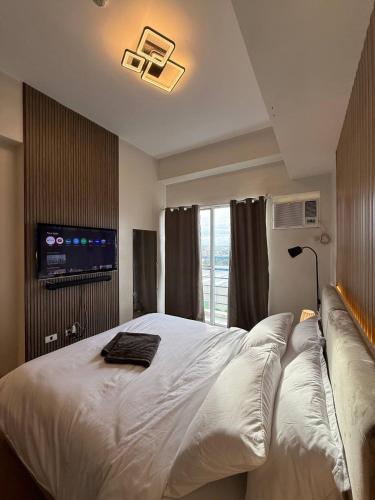 a bedroom with a large white bed and a couch at Cozy Space in the City in Cagayan de Oro