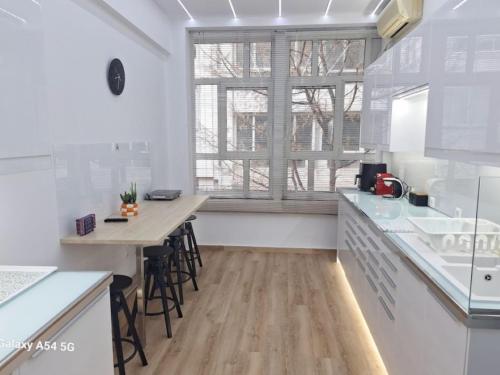a kitchen with white counters and a large window at AS luxury apartment in Athens