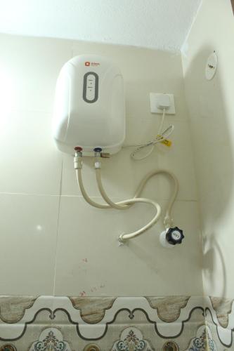 a bathroom with a hair dryer on the wall at Fort Square Apartments - 102 in Vellore