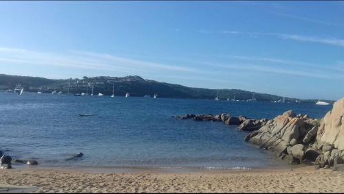 a body of water with a beach and rocks at Marana apartments with private beach in Santa Marinella