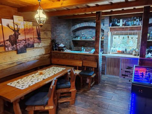 a dining room with a table and a bar at Chata na SAMOTE in Jedľové Kostoľany