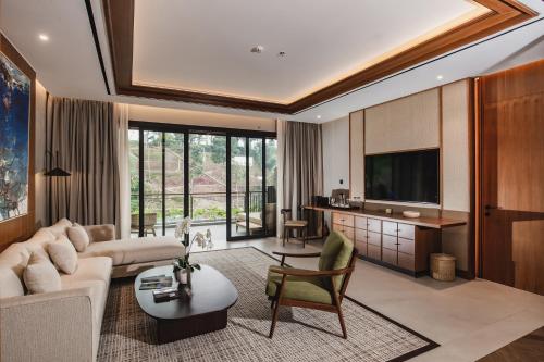 a living room with a couch and a tv at Plataran Puncak Suites in Puncak