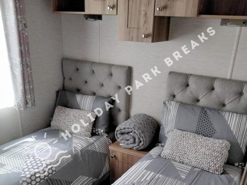 a bedroom with two twin beds in a room at Valeria - Gold 3 bedroom with Garden and Parking - Seal Bay in Selsey