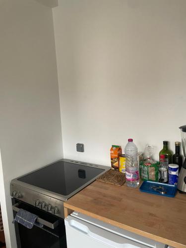 une cuisine avec une cuisinière et un comptoir avec de l'alcool dans l'établissement Appartement, à Aubervilliers