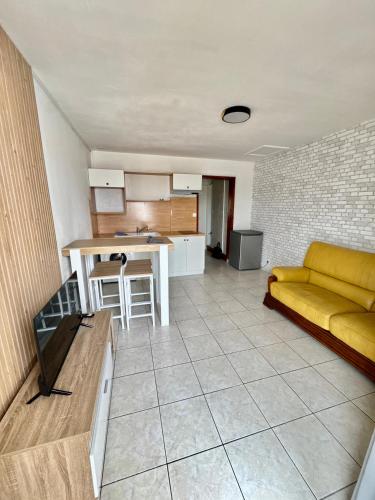 a living room with a yellow couch and a kitchen at T2 Spacieux, Lumineux et Centrale in Istres