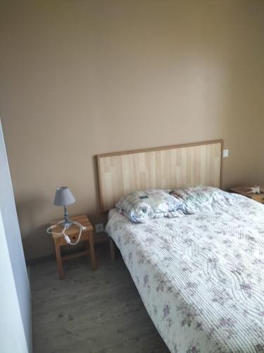 une chambre avec un lit et une table avec une lampe dans l'établissement Le devezou Malons et Elze, à Malons-et-Elze