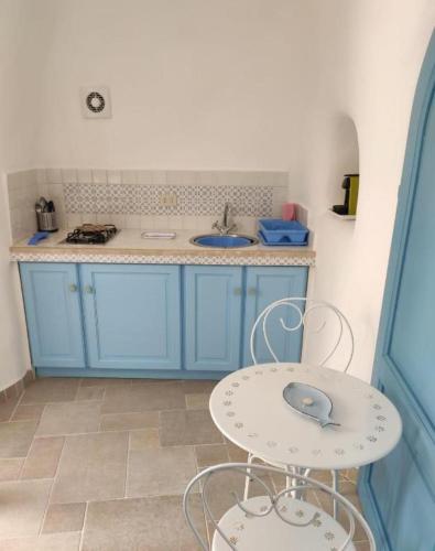 a kitchen with blue cabinets and a table with a mouse on it at Maridea - Cave Apartments in Ponza
