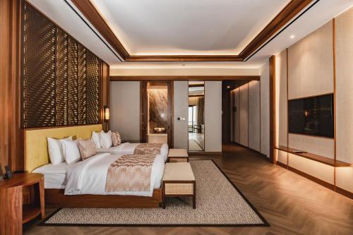 a bedroom with a large bed and a tv at Plataran Puncak Suites in Puncak