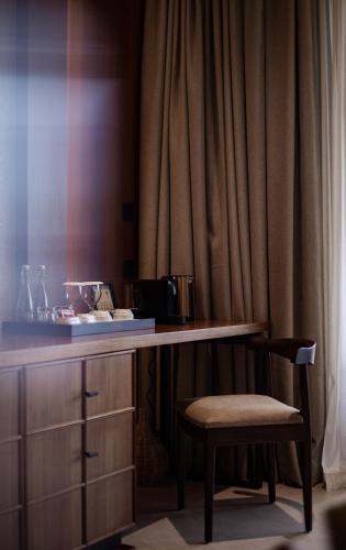 a desk with a chair next to a curtain at Plataran Puncak Suites in Puncak