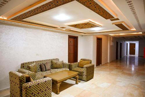 a living room with couches and a table at Hôtel Jawharat El Jadida in El Jadida