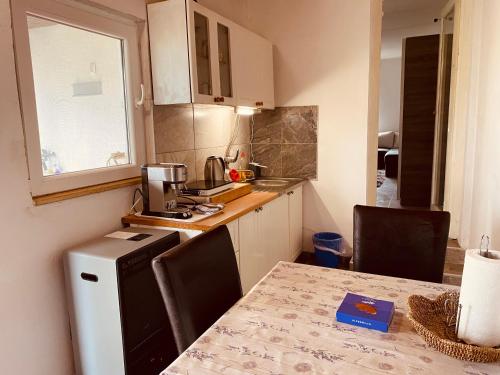a small kitchen with a table and a refrigerator at Kuća za odmor Bećarsko Utočište in Vinkovci