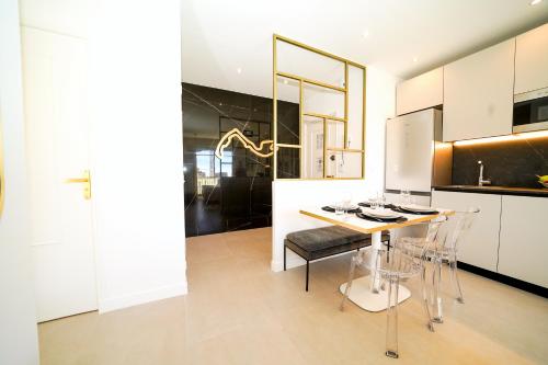 une cuisine avec une table et des chaises dans une pièce dans l'établissement Monaco - Charm and comfort 4-6 people with parking, à Beausoleil