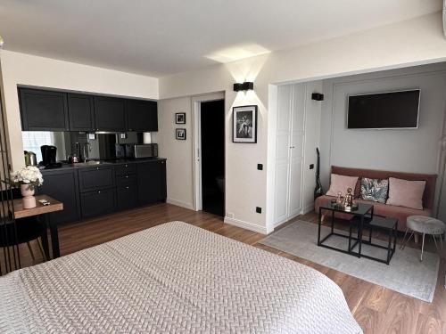 Cet appartement comprend une chambre avec un lit et un canapé ainsi qu'une cuisine. dans l'établissement Modern studio in the hearth of Cannes just a few steps from the Croisette beach front and shops - 2242, à Cannes