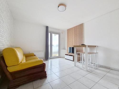 a living room with a yellow chair and a table at T2 Spacieux, Lumineux et Centrale in Istres