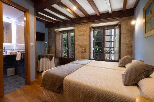a bedroom with a large bed and a bathroom at PR Badalada in Santiago de Compostela
