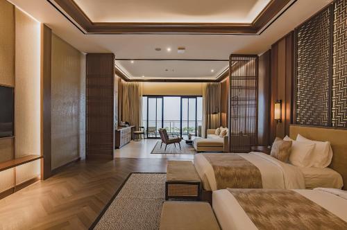 a hotel room with two beds and a living room at Plataran Puncak Suites in Puncak