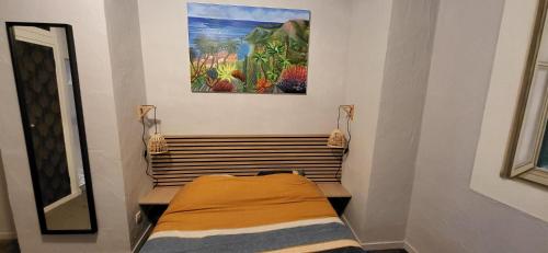 un lit dans une chambre avec un tableau sur le mur dans l'établissement Au Coeur du vieux Nice, à Nice