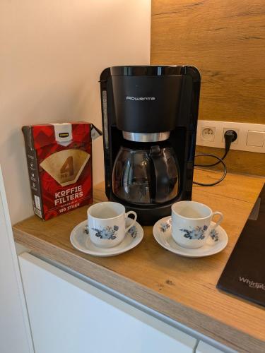 a coffee maker and two cups on a counter at Au Bois Chantant in Somme-Leuze