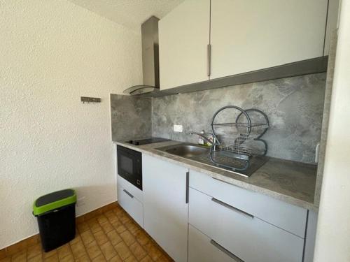 une cuisine avec un évier et un plan de travail dans l'établissement CAP D'AGDE Studio Cabine 046- 4 personnes Résidence avec piscine quartier Môle, au Cap d'Agde