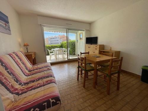 un salon avec un canapé et une table dans l'établissement CAP D'AGDE Studio Cabine 046- 4 personnes Résidence avec piscine quartier Môle, au Cap d'Agde