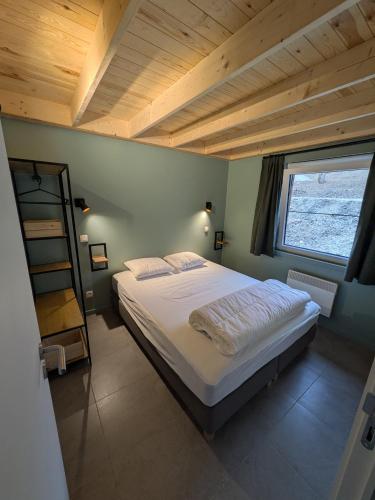a bedroom with a bed with a wooden ceiling at Au Bois Chantant in Somme-Leuze