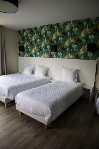 two beds in a room with a painting on the wall at Auberge du château de Joux in La Cluse et Mijoux