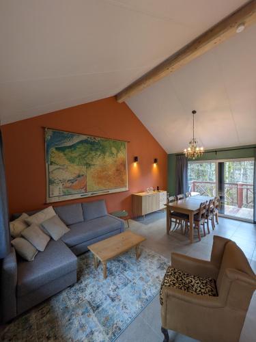 a living room with a couch and a table at Au Bois Chantant in Somme-Leuze
