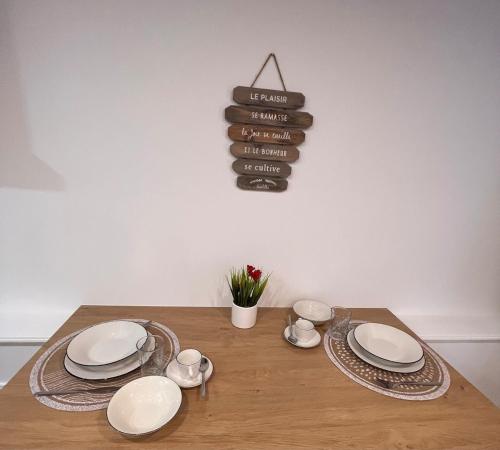 une table en bois avec des assiettes et des cuillères dans l'établissement Charme et Authenticité à Menton - Centre & Plages, à Menton