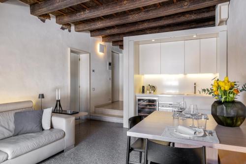 a kitchen and living room with a couch and a table at Luxury Apartment on Piazza Erbe in Verona