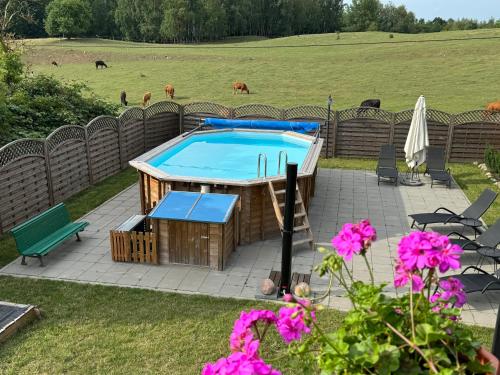 a pool with a table and a bench and flowers at Siedlisko na Górce in Zalec