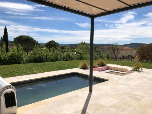 - une piscine sur une terrasse avec un parasol dans l'établissement La Petite Reine, à Villes-sur-Auzon