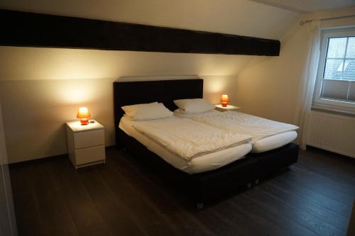 a bedroom with a bed with two candles on two tables at Pension Forke in Wilhelmshaven