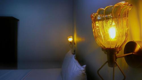 a bedroom with a bed with a yellow light on the wall at Dambulla Village Hotel & Restaurant in Dambulla