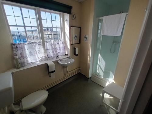 a bathroom with a sink and a toilet and a shower at Royal Norfolk & Suffolk Yacht Club in Lowestoft