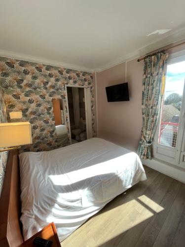 a bedroom with a white bed and a window at Aux Quatre Vents in Saulieu