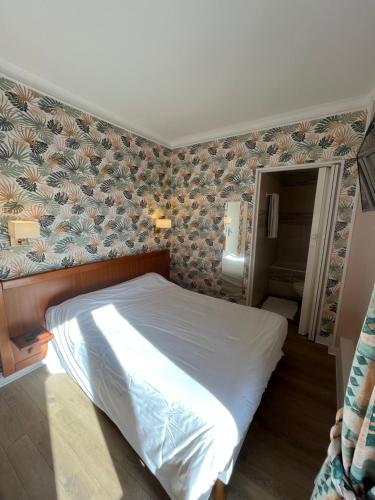 a bed in a bedroom with a wall at Aux Quatre Vents in Saulieu