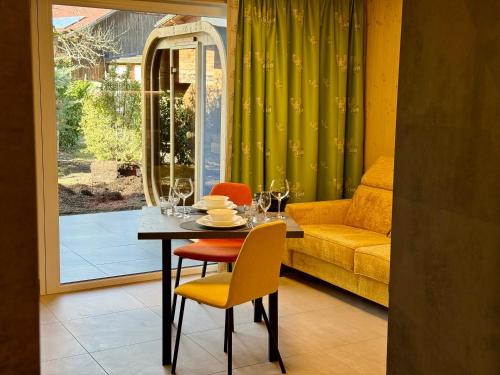 a dining room with a table and chairs and a couch at TinyHome Singer - inclusive private Sauna in Ehenbichl