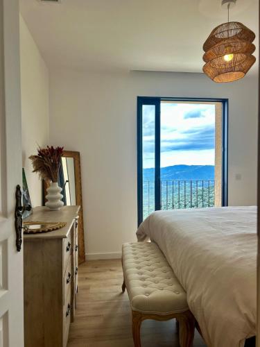 une chambre avec un lit et une grande fenêtre dans l'établissement La villa Orso, piscine chauffée , vue panoramique, à Sollacaro