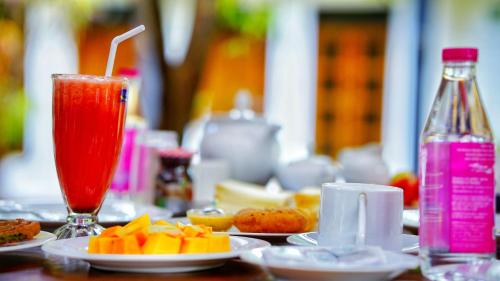a table topped with plates of food and a drink at Dambulla Village Hotel & Restaurant in Dambulla