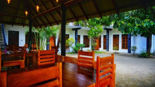 a restaurant with wooden chairs and a building at Dambulla Village Hotel & Restaurant in Dambulla