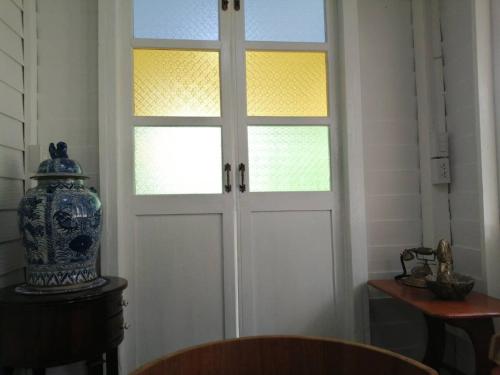 a door with a window and a vase in a room at Baan Chay Klong, Canal side Classic Home 2BRs in Ban Bang Toei (1)