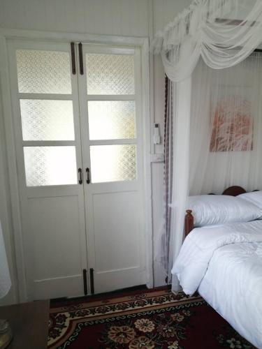 a bedroom with a door and a bed and a window at Baan Chay Klong, Canal side Classic Home 2BRs in Ban Bang Toei (1)