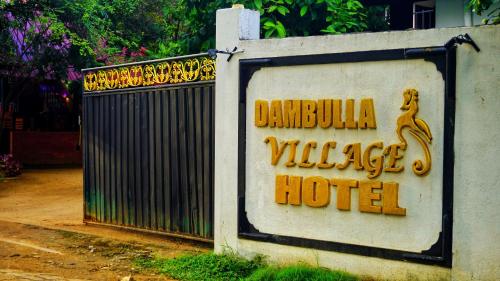 a sign for a hotel in front of a gate at Dambulla Village Hotel & Restaurant in Dambulla