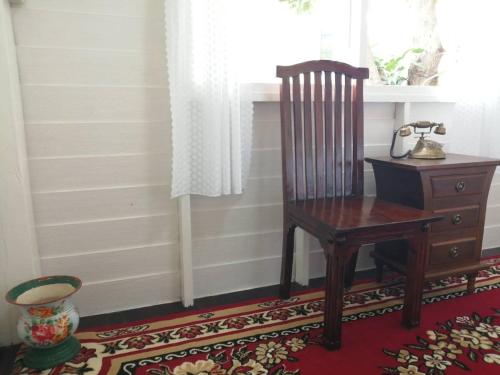 a wooden chair next to a desk and a window at Baan Chay Klong, Canal side Classic Home 2BRs in Ban Bang Toei (1)