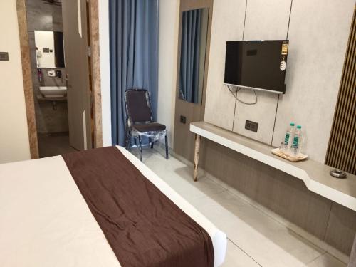 ein Hotelzimmer mit Bett und Flachbildfernseher in der Unterkunft Hotel Tarun Palace, Bhopal in Bhopal