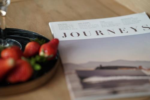 a bowl of strawberries on a table next to a book at Rooftop Chalet 2-Level Apartment in Old Town in Zürich