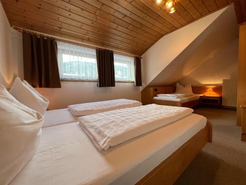 a bedroom with two beds and two windows at Hoamat House I Boutique Apartments in Sankt Margarethen im Lungau