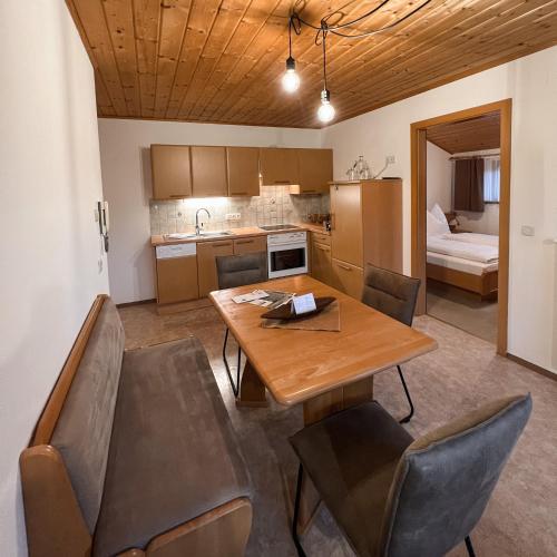 a kitchen and dining room with a wooden table and chairs at Hoamat House I Boutique Apartments in Sankt Margarethen im Lungau