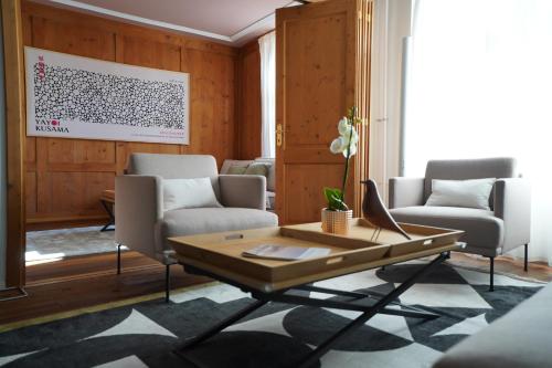 a living room with two chairs and a table at Rooftop Chalet 2-Level Apartment in Old Town in Zürich