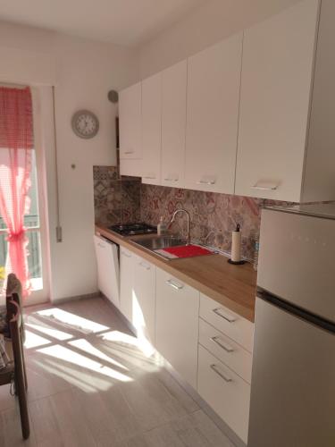 a kitchen with white cabinets and a sink at Casa del Celo in Rapallo
